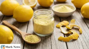 Barattolo e cucchiaio con polvere di limone su tavolo di legno, con limoni interi e bucce essiccate